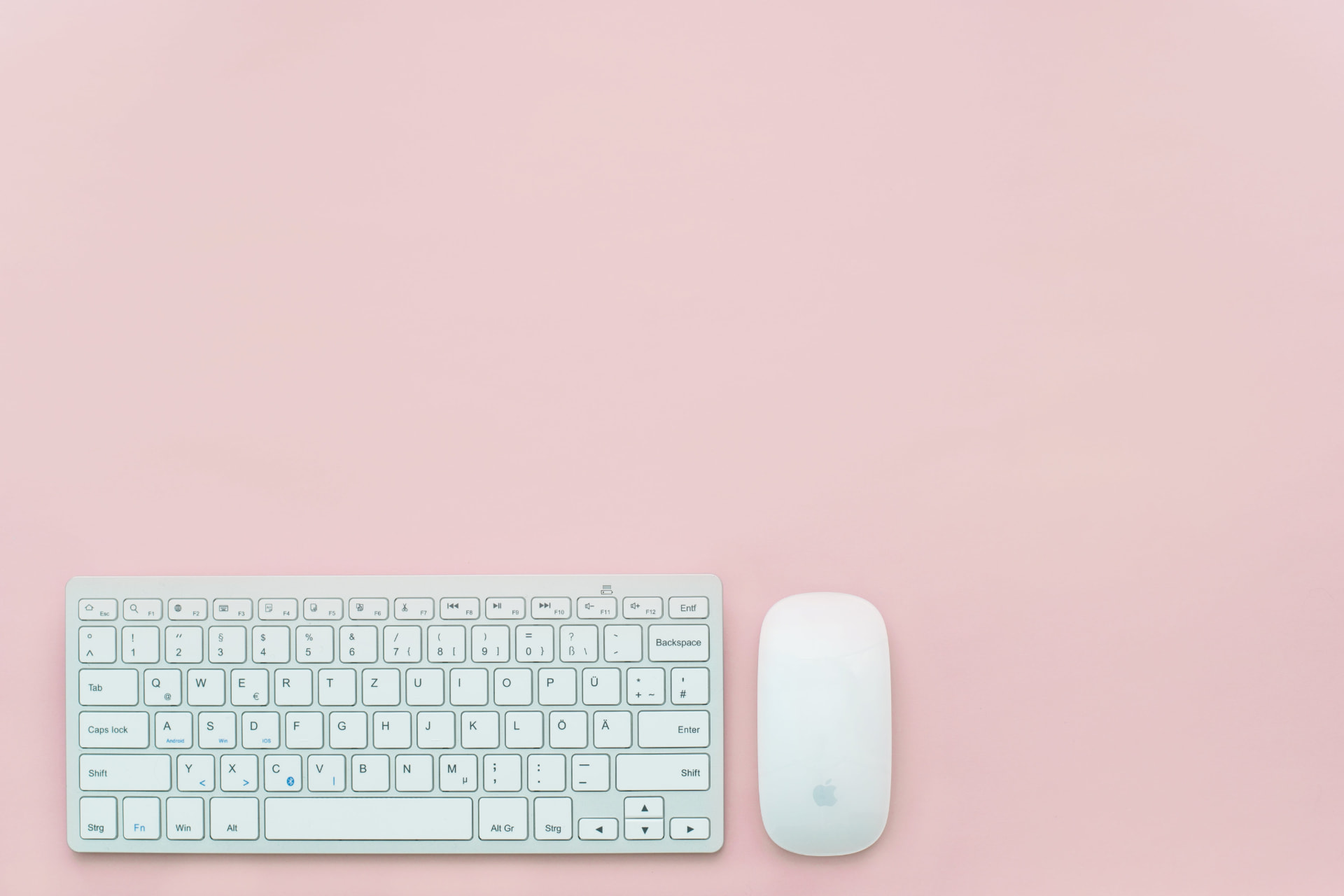 Pink workspace with a keyboard and mouse